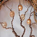 twisted brown aluminum branches are decorated with textured, shiny, sand, dirt, earth color beads